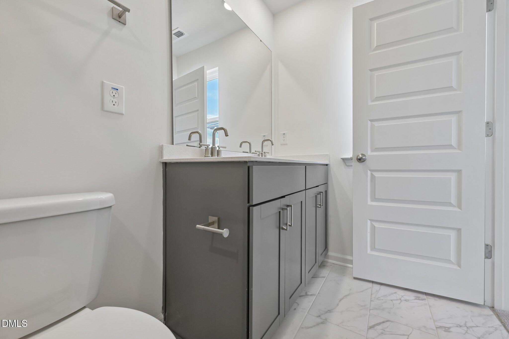 2206 Rabbitbrush Street Durham, NC 27704 - Photo 36 of 49 a bathroom with a sink a toilet and a mirror