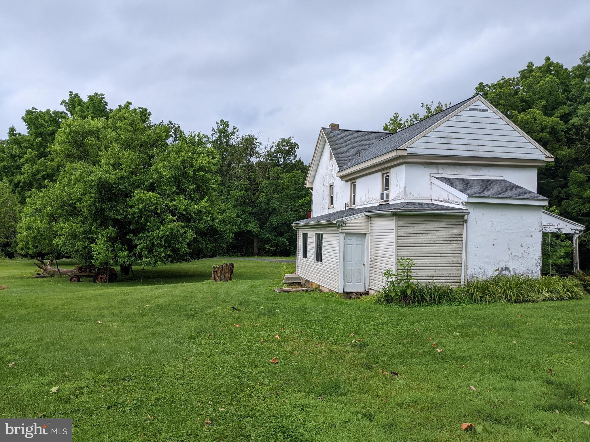 79 Spotts Mill Road Douglassville, PA 19518 - Photo 25 of 27 a white house with a small yard and trees in the background