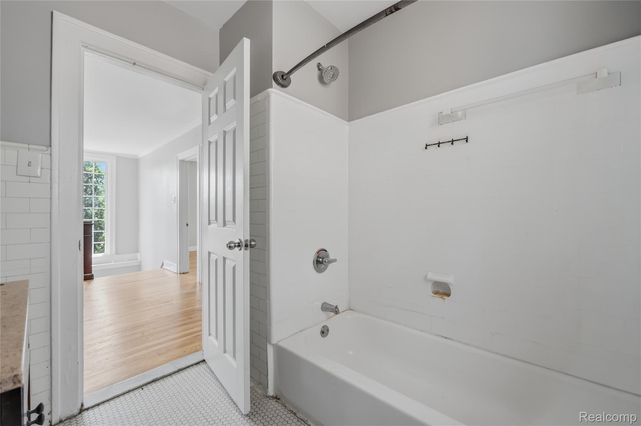 1945 Atkinson Street Detroit, MI 48206 - Photo 34 of 49 Bathroom featuring a shower-over-tub combination with chrome fixtures, white subway tile accents, and hexagonal mosaic floor tiles
