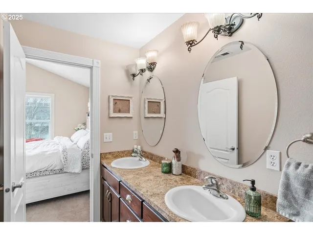 a en suite bathroom with a granite countertop sink and mirror