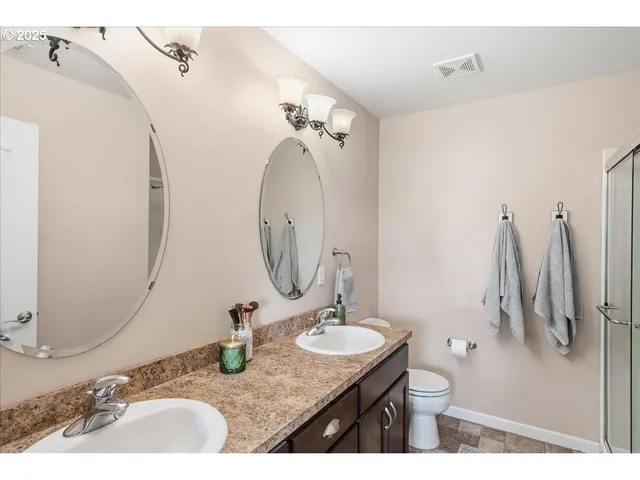 a bathroom with a granite countertop sink a toilet and a mirror