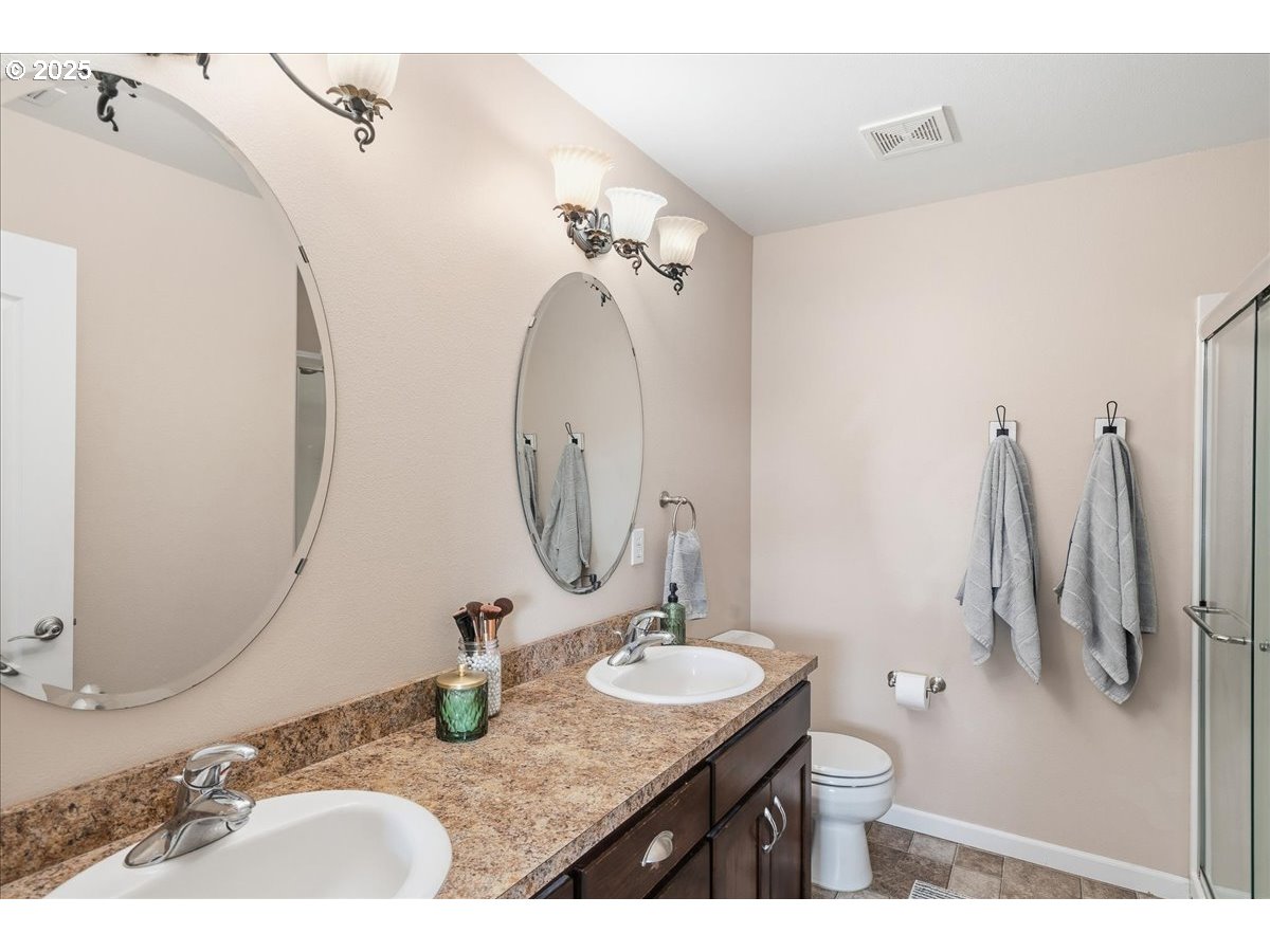 1010 Turtledove Loop Lebanon, OR 97355 - Photo 24 of 36 a bathroom with a granite countertop sink a toilet and a mirror