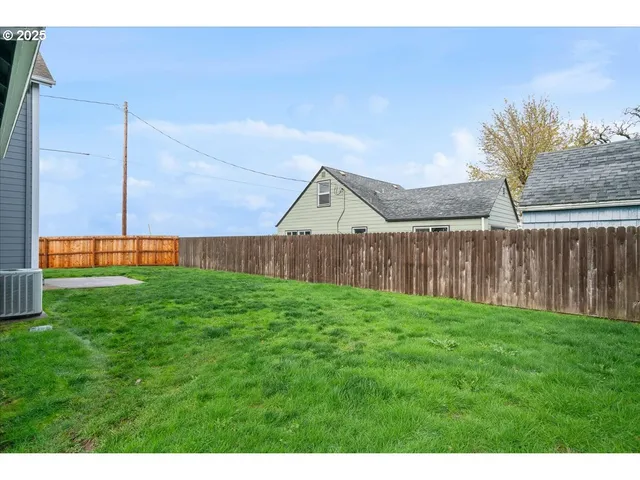 a view of backyard with wooden fence