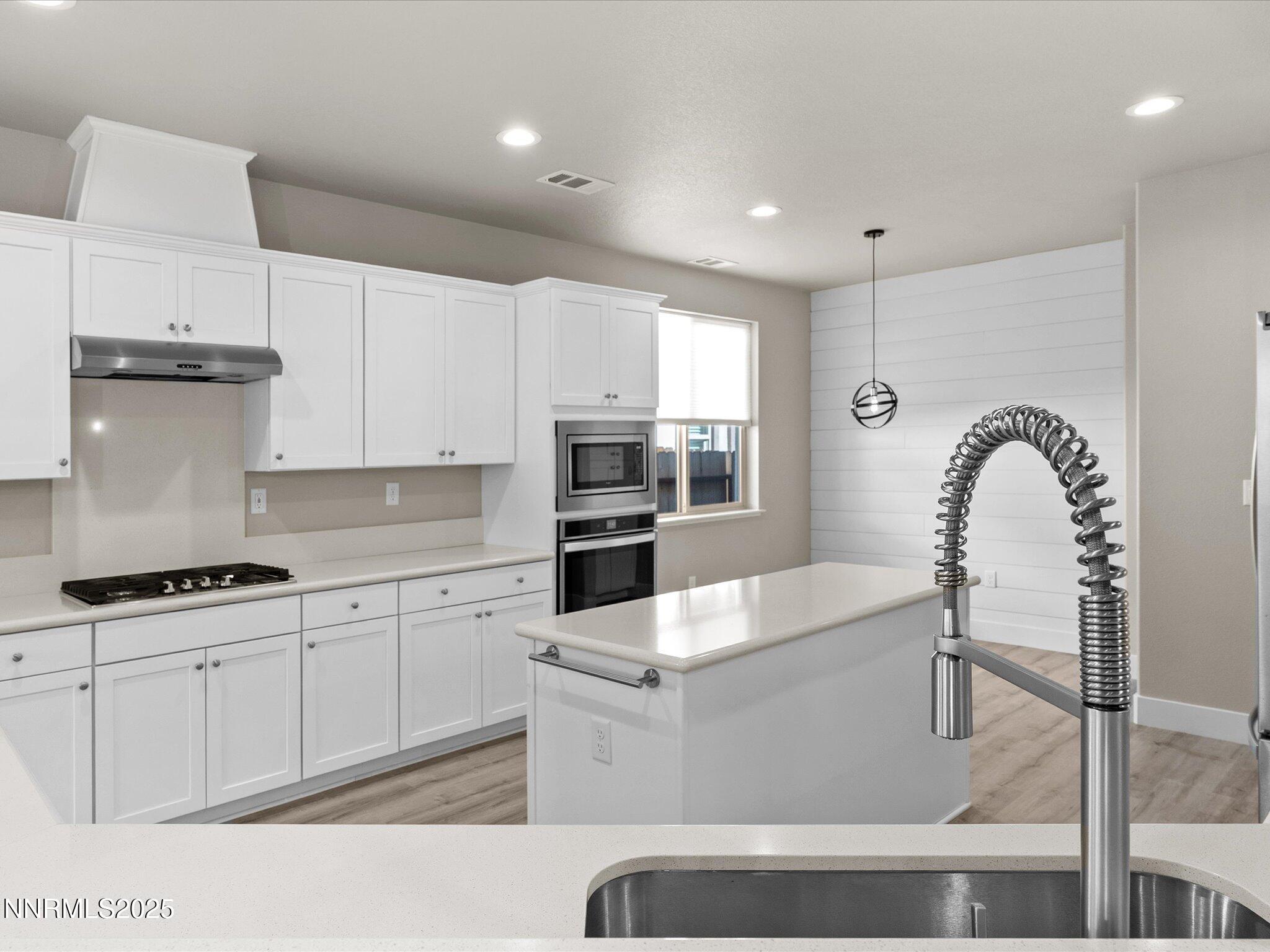 770 East Cottage Loop Gardnerville, NV 89460 - Photo 11 of 38 a kitchen with kitchen island granite countertop a stove a sink and white cabinets