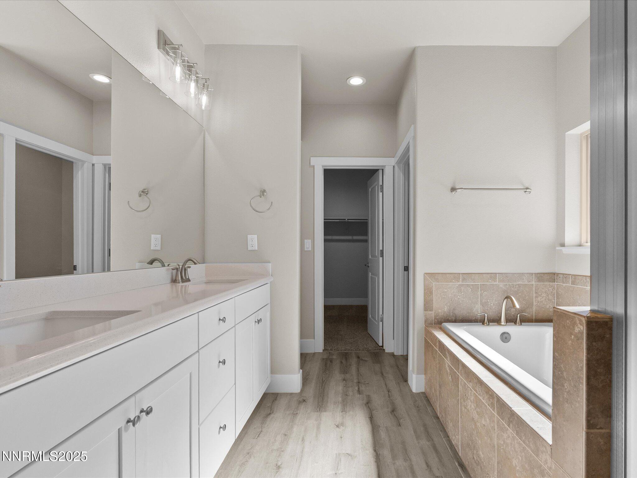 770 East Cottage Loop Gardnerville, NV 89460 - Photo 24 of 38 a spacious bathroom with a granite countertop double vanity sink a mirror and a bathtub