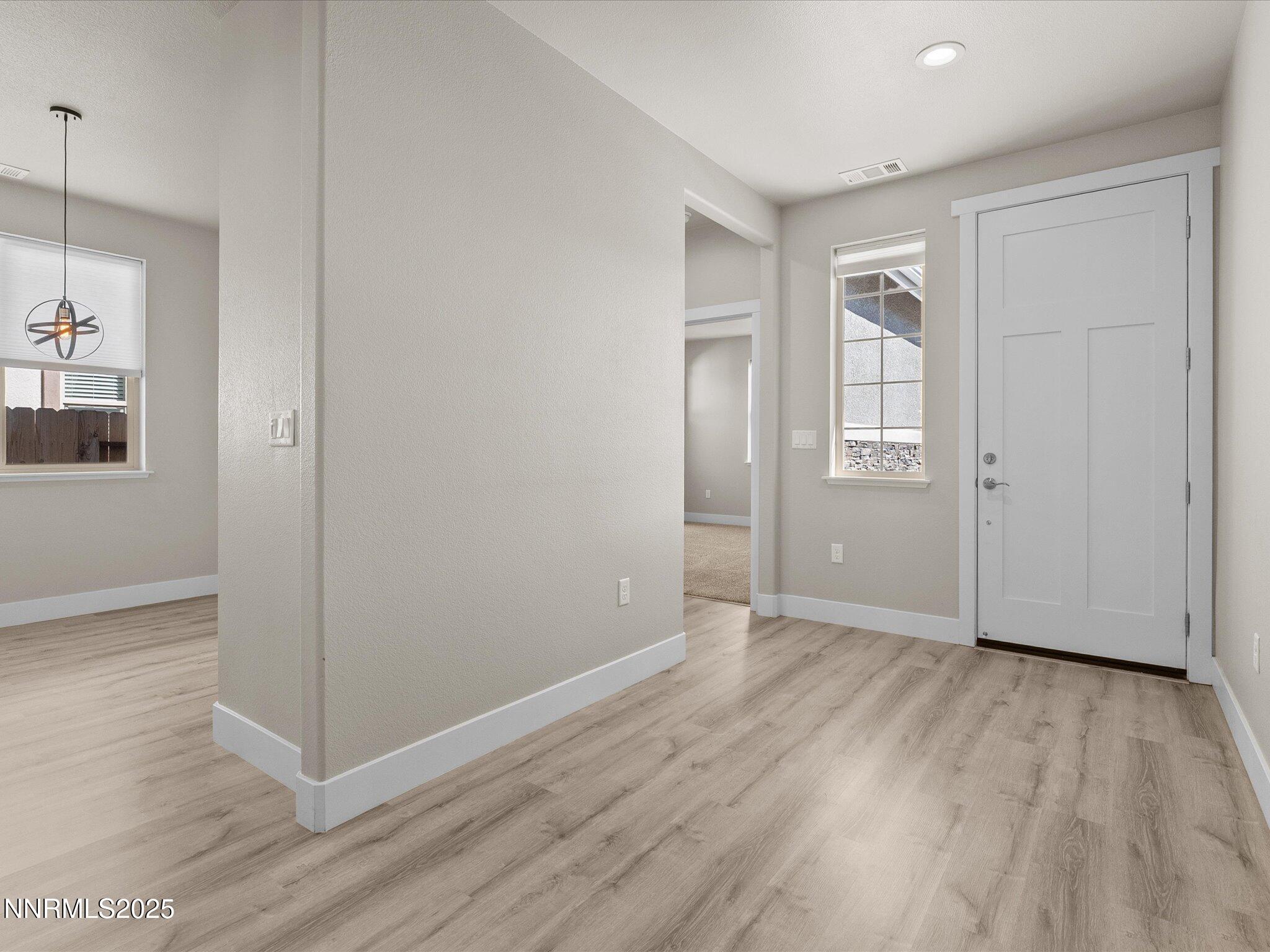 770 East Cottage Loop Gardnerville, NV 89460 - Photo 5 of 38 a view of an empty room with wooden floor and a window