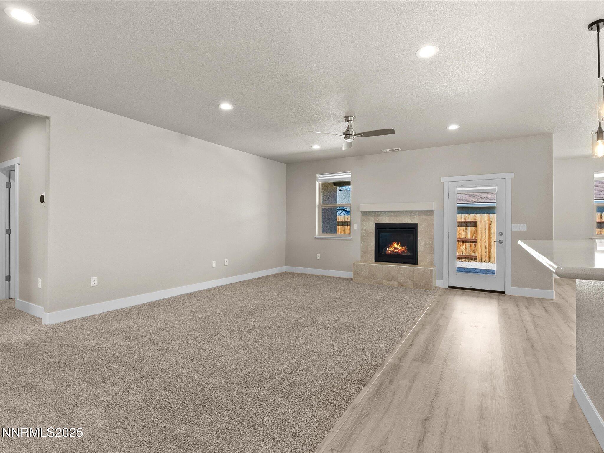 770 East Cottage Loop Gardnerville, NV 89460 - Photo 6 of 38 an empty room with wooden floor fireplace and windows