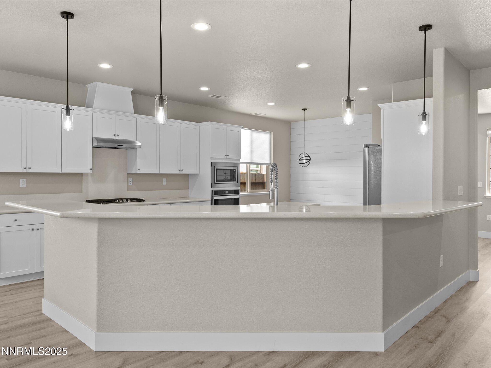 770 East Cottage Loop Gardnerville, NV 89460 - Photo 10 of 38 a large kitchen with kitchen island a sink a center island and stainless steel appliances