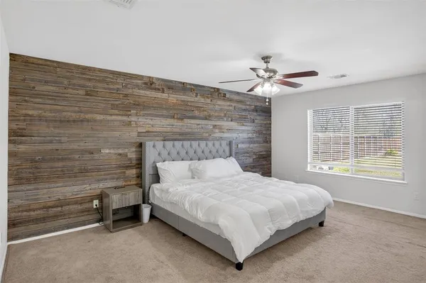 a bedroom with a bed and a ceiling fan