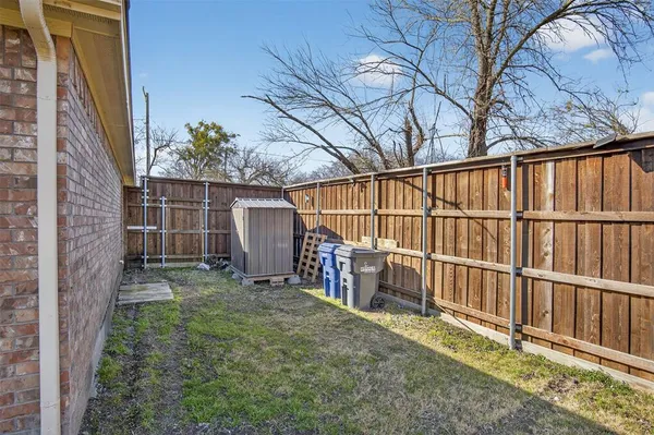 a backyard of a house with lots of green space and wooden fence