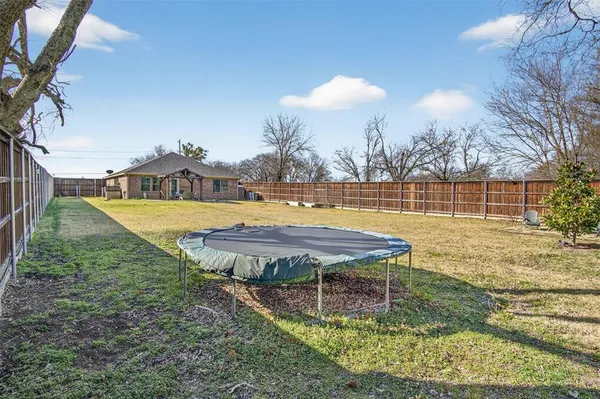 a view of a swimming pool with a patio and a yard