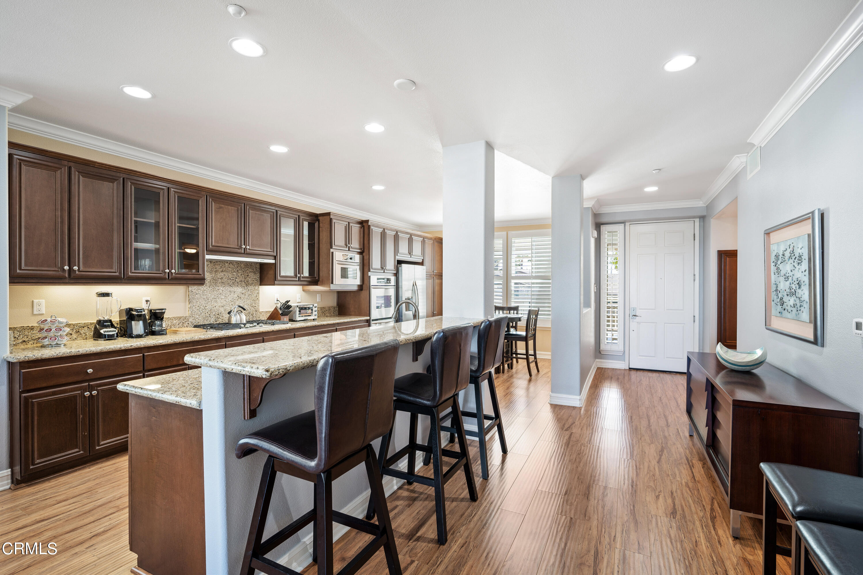 1541 Windshore Way Oxnard, CA 93035 - Photo 4 of 40 a kitchen with stainless steel appliances granite countertop wooden floors stove refrigerator and cabinets