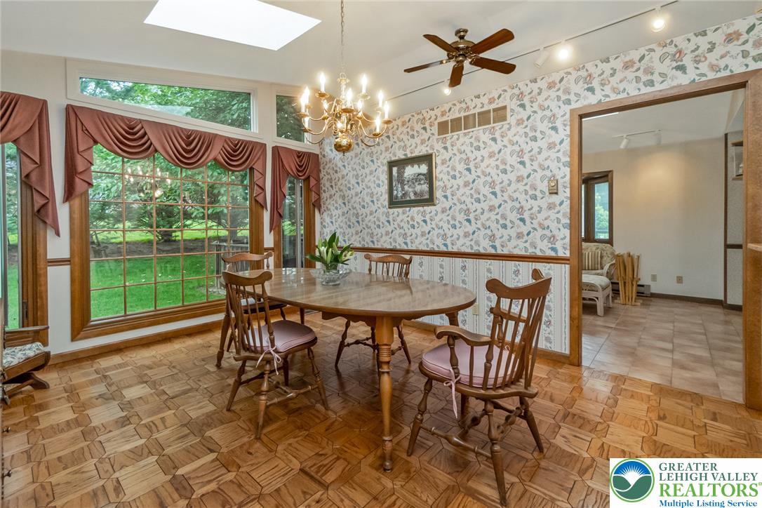 1328 Russett Road Allentown, PA 18104 - Photo 21 of 46 A skylight-illuminated dining area boasts parquet flooring and expansive windows with outdoor views.