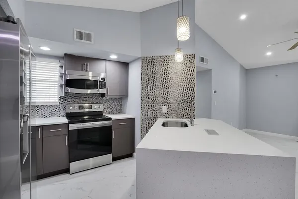 a kitchen with stainless steel appliances granite countertop a sink and a stove
