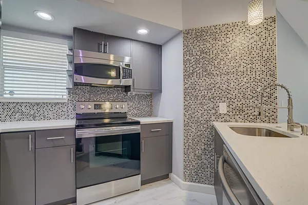 a kitchen with stainless steel appliances a refrigerator sink and microwave