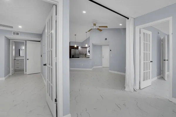 en empty room with closet and a chandelier fan