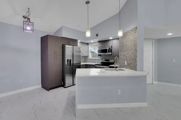 a kitchen with stainless steel appliances a refrigerator sink and microwave