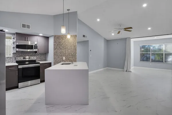 a kitchen with a sink a stove and microwave