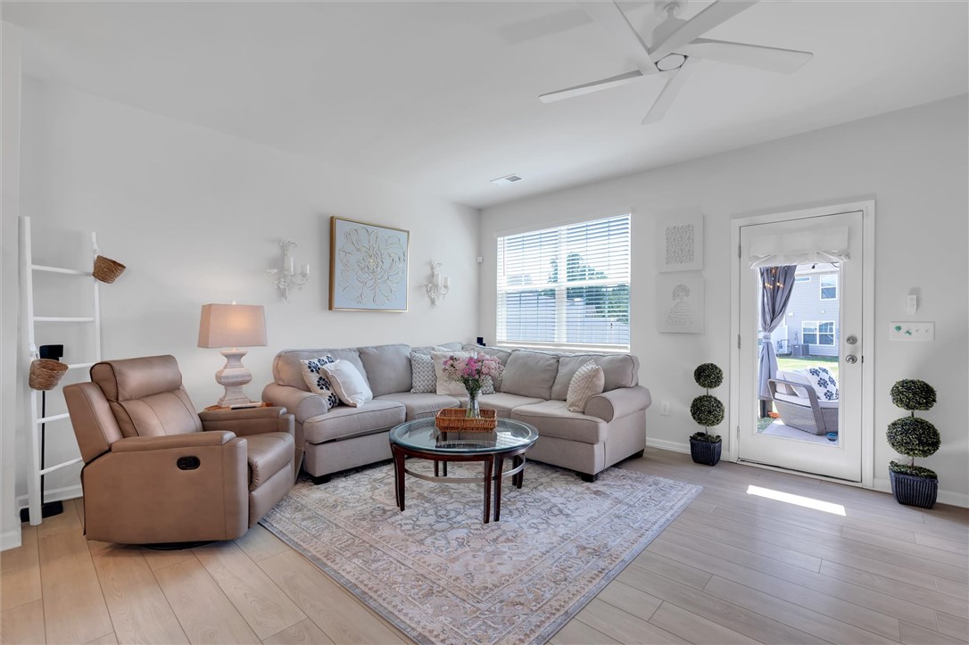 453 Bee Cv Way Pendleton, SC 29670 - Photo 9 of 25 Natural light flows into the family room with gorgeous LVP flooring leading to direct access to a private outdoor space.