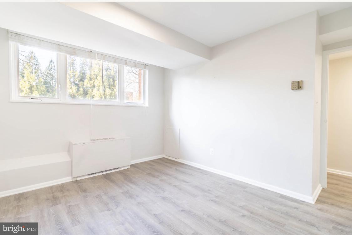 2400 41st Street Northwest, Unit 104 Washington, DC 20007 - Photo 10 of 13 an empty room with wooden floor and windows