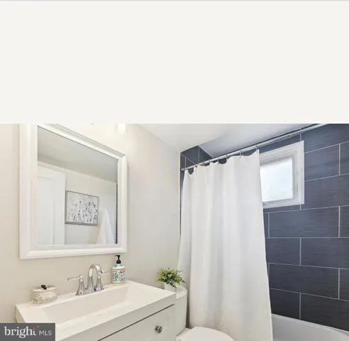 a bathroom with a sink a mirror and a shower curtain
