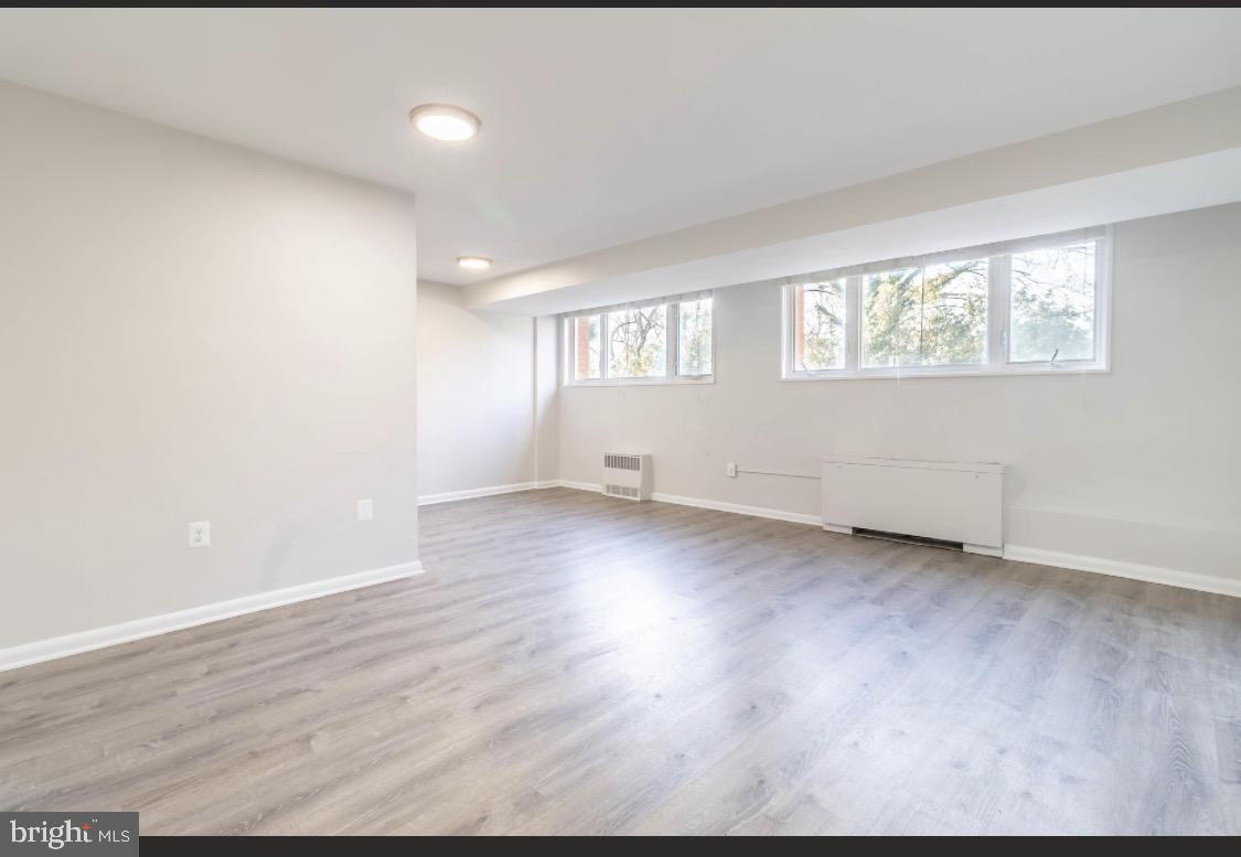 2400 41st Street Northwest, Unit 104 Washington, DC 20007 - Photo 13 of 13 an empty room with wooden floor and windows
