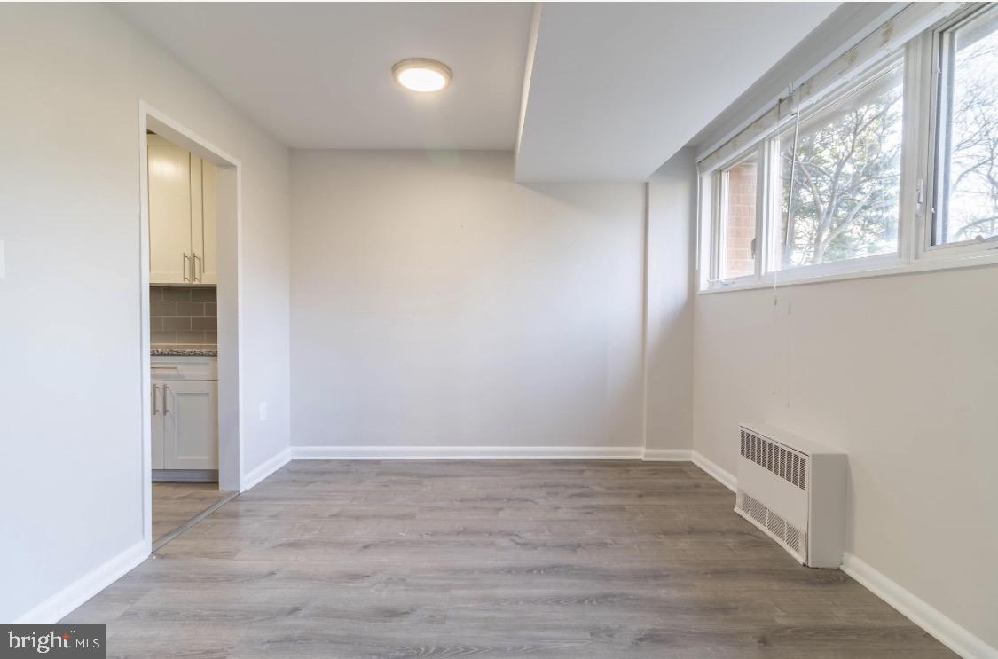 2400 41st Street Northwest, Unit 104 Washington, DC 20007 - Photo 5 of 13 an empty room with wooden floor and windows