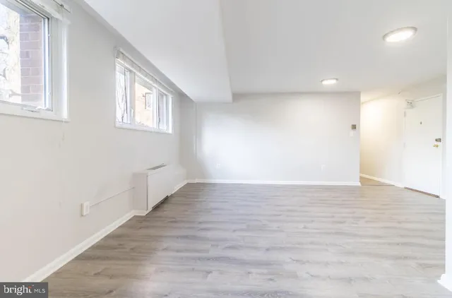 a view of an empty room with wooden floor