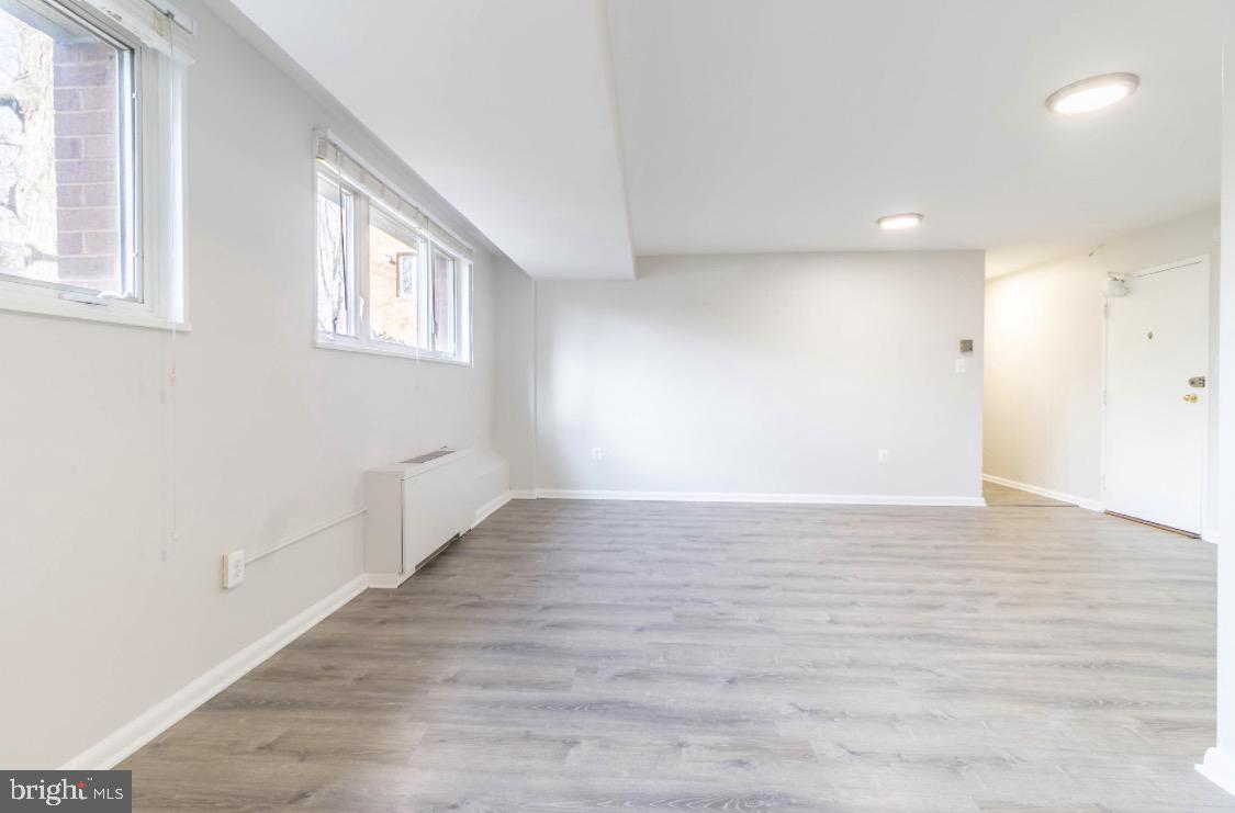 2400 41st Street Northwest, Unit 104 Washington, DC 20007 - Photo 7 of 13 a view of an empty room with wooden floor and a window