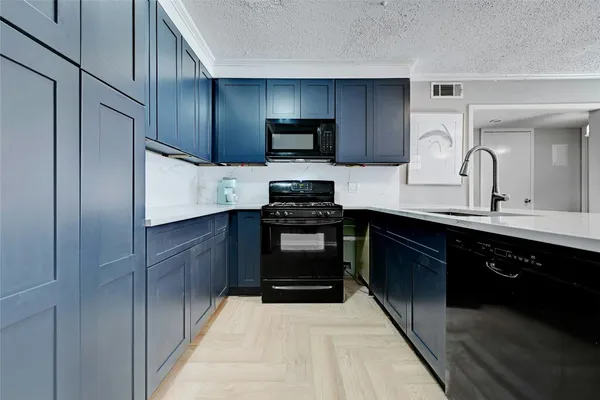 a kitchen with stainless steel appliances a stove sink microwave and cabinets