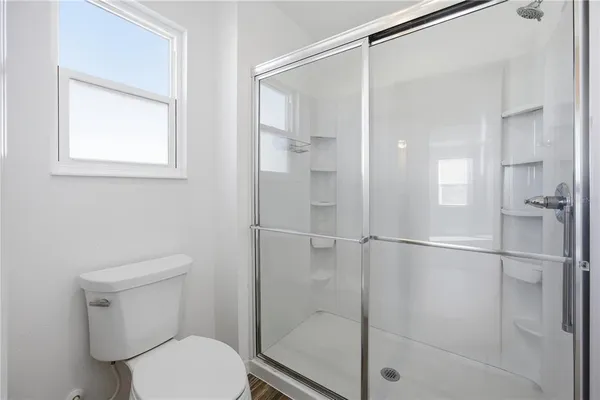 a bathroom with a toilet and a shower