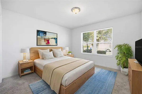 a bedroom with a large bed and a potted plant