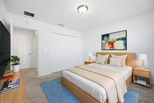 a bedroom with bed and paintings on the wall