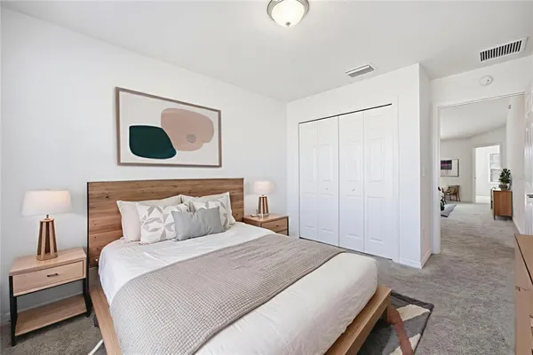 a bedroom with a bed and painting on the wall