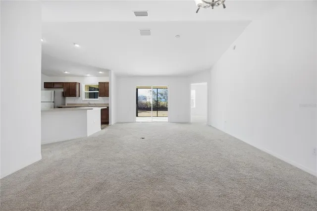 a view of a kitchen with a sink stove cabinets and entertaining space