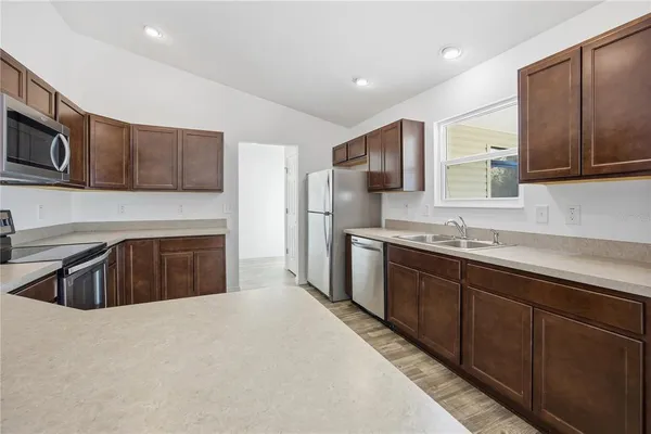 a kitchen with stainless steel appliances granite countertop a sink stove and refrigerator