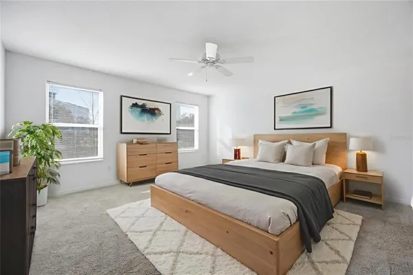 a spacious bedroom with a bed and a potted plant