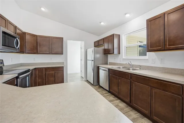 a kitchen with stainless steel appliances granite countertop a sink stove and refrigerator