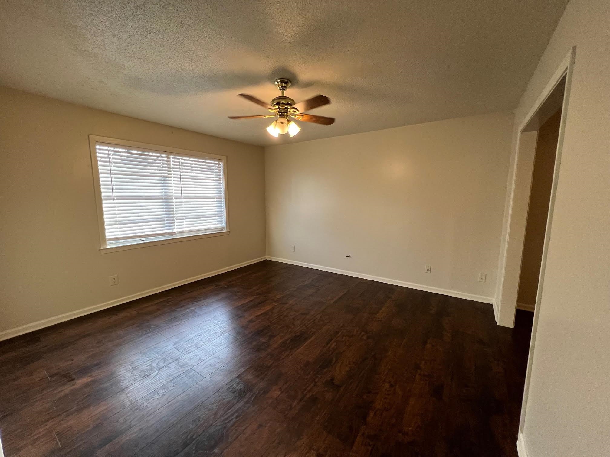 4178 Crain Road Memphis, TN 38128 - Photo 3 of 9 an empty room with wooden floor fan and windows