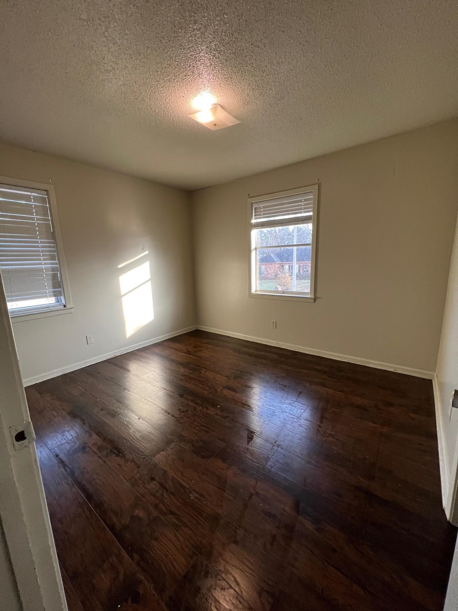4178 Crain Road Memphis, TN 38128 - Photo 7 of 9 an empty room with wooden floor and windows