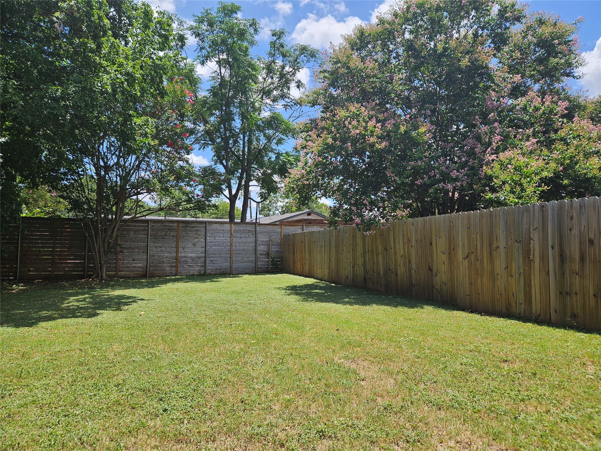 806 Ranch Road, Unit A Georgetown, TX 78628 - Photo 13 of 24 A generous backyard offers a verdant lawn enclosed by privacy fencing, perfect for outdoor enjoyment.