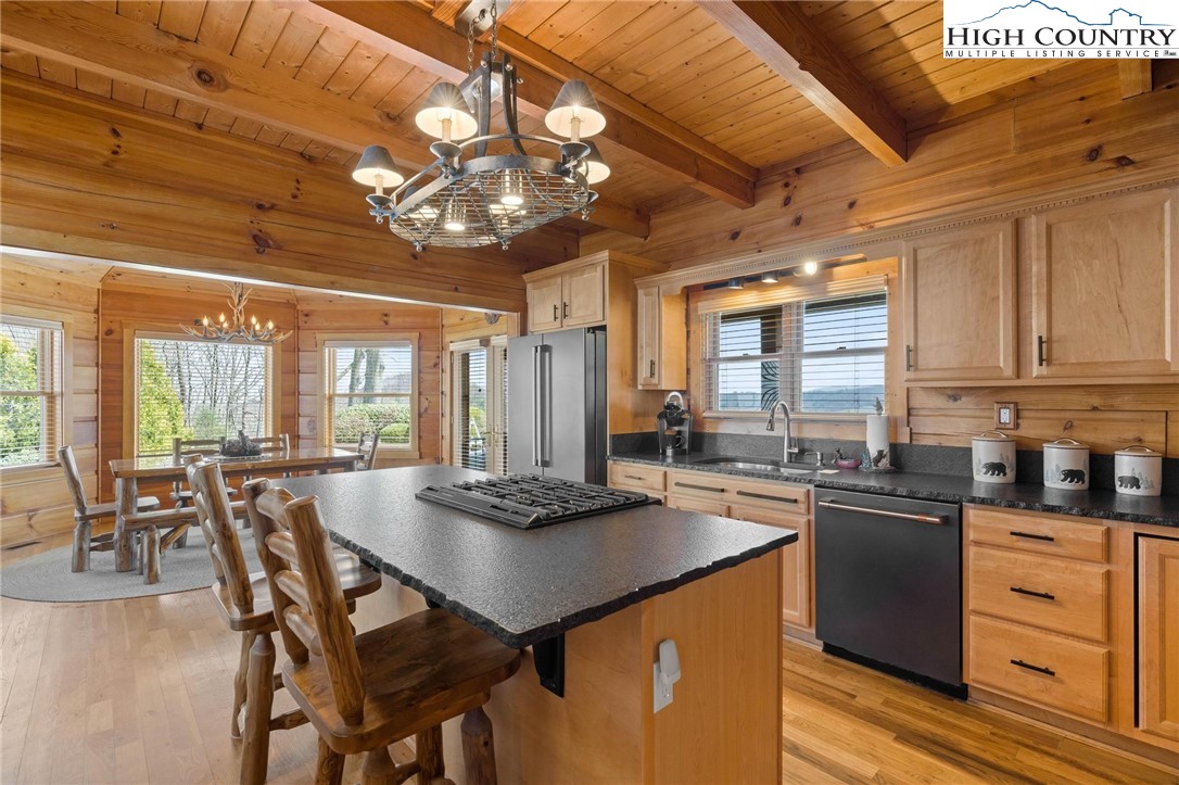 184 Avalanche Trail Boone, NC 28607 - Photo 15 of 46 a kitchen with stainless steel appliances granite countertop a stove a refrigerator a dining table and chairs with wooden floor