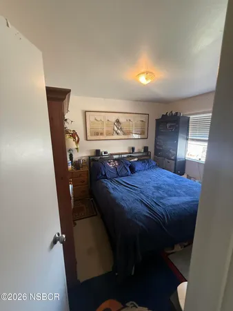 a bed sitting in a bedroom next to a window