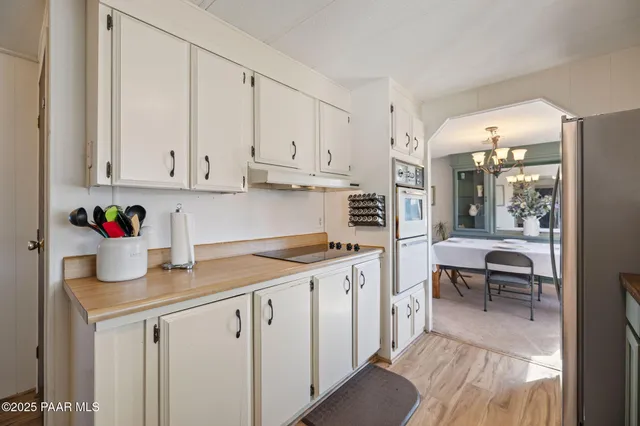 a kitchen with white cabinets and sink