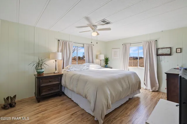 a bedroom with a bed and a mirror on the dresser