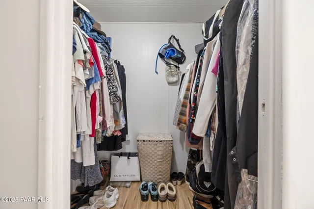 a view of walk in closet with clothes and shoes