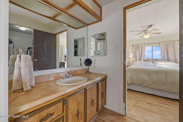 a en suite bathroom with a granite countertop double vanity sink and a mirror
