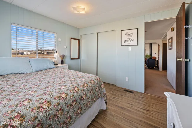 a bedroom with a bed and wooden floor