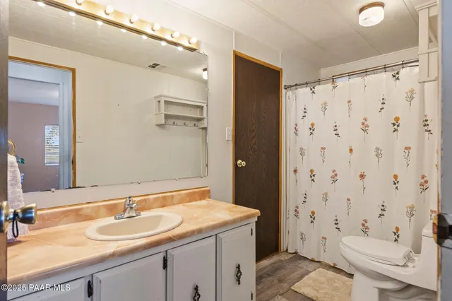 a bathroom with a granite countertop sink toilet and shower