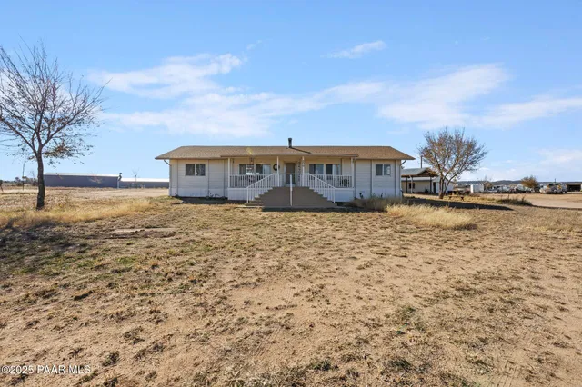a view of a terrace with wooden fence and trees
